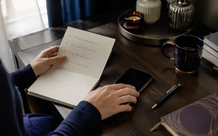 Carnet de questions et téléphone avant un premier appel sur une plateforme de voyance